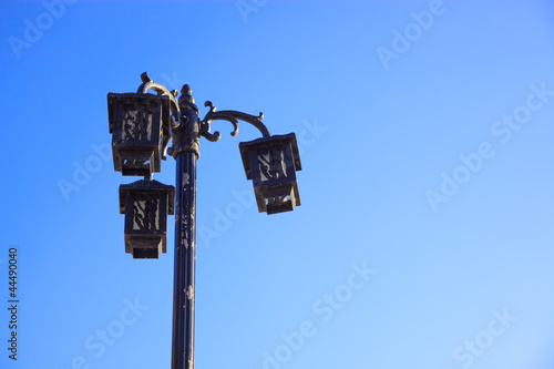 Retro-styled streetlight under blue sky at sunrise