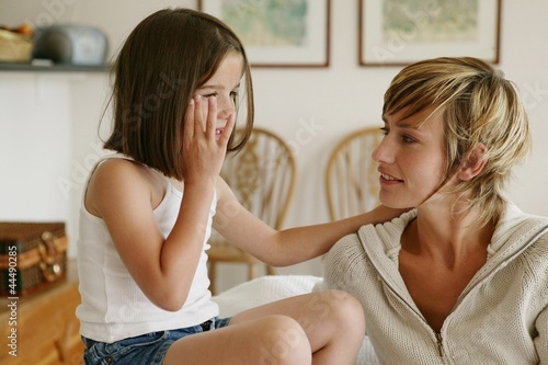 Little girl whispering secrets to her mom photo