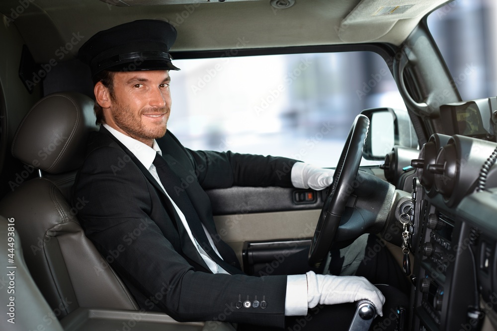 Handsome chauffeur driving limousine smiling Handsome chauffeur driving limousine smiling