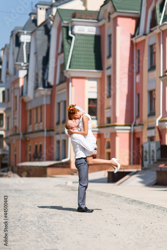 Groom kissing bride on their wedding walk © Dmytro Synelnychenko