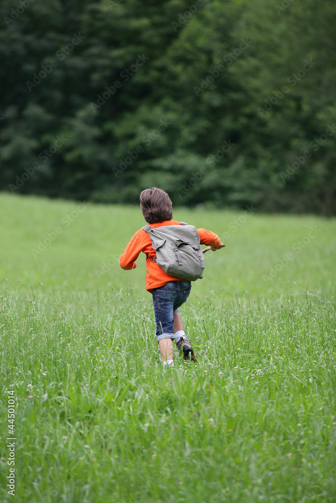 Fototapeta premium Boy running through the grass