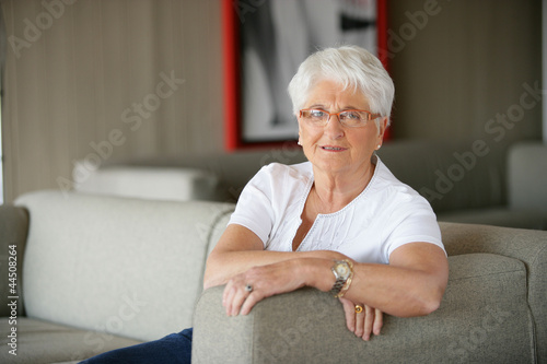Elderly lady relaxing on sofa