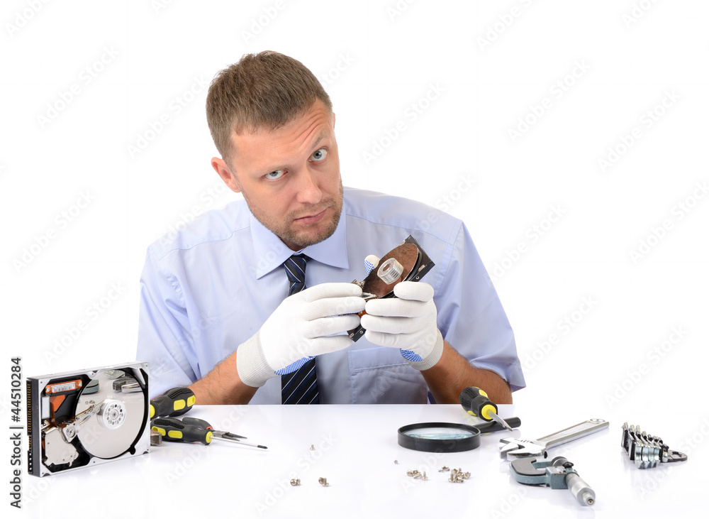 Man wearing gloves repairs hard drive on white background