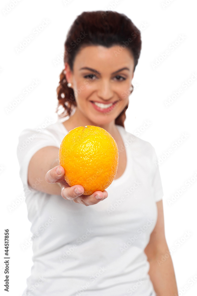 Smiling beautiful woman offering you an orange Smiling beautiful woman offering you an orange