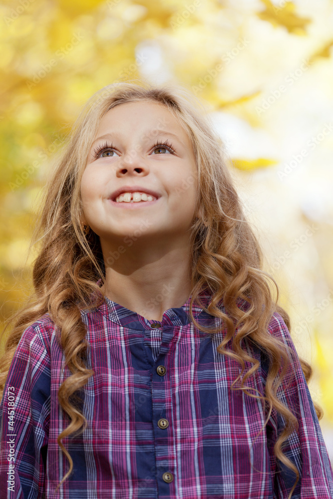 beautiful little girl on walk in autumn park