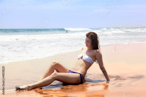 beautiful girl sunbathes on an ocean coast