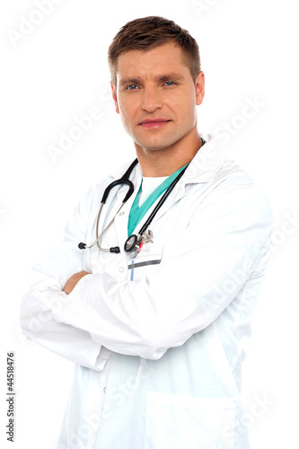 Handsome young doctor posing with crossed arms © stockyimages