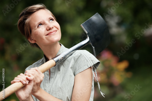 lovely young woman, portrait in the garden with spade