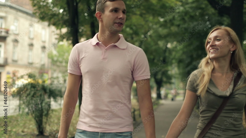 Happy young couple walking in the park, steadicam shot Happy young couple walking in the park, steadicam shot