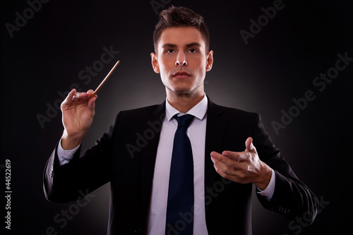 Young businessman directing with a conductor's stick