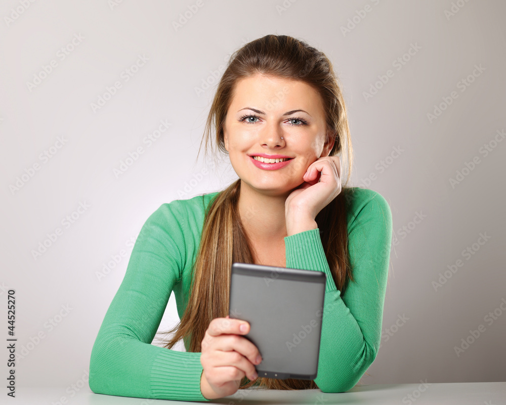 Fototapeta premium Young woman sitting and holding computer plane-table
