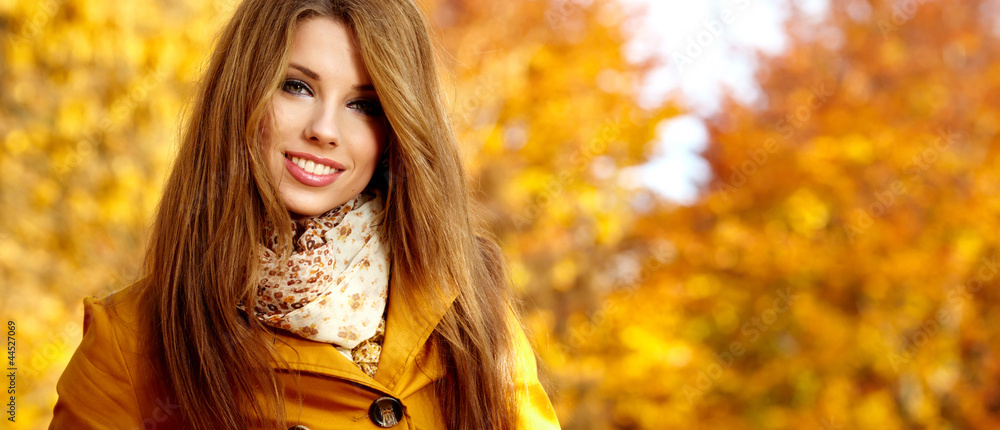 Beautiful elegant woman standing in a park in autumn Beautiful elegant woman standing in a park in autumn