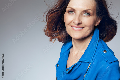 Happy middle-aged woman in blue jacket.