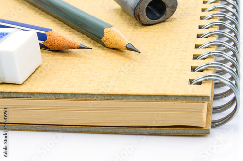 Two Wooden pencil, eraser and sharpener on recycle notebook on w