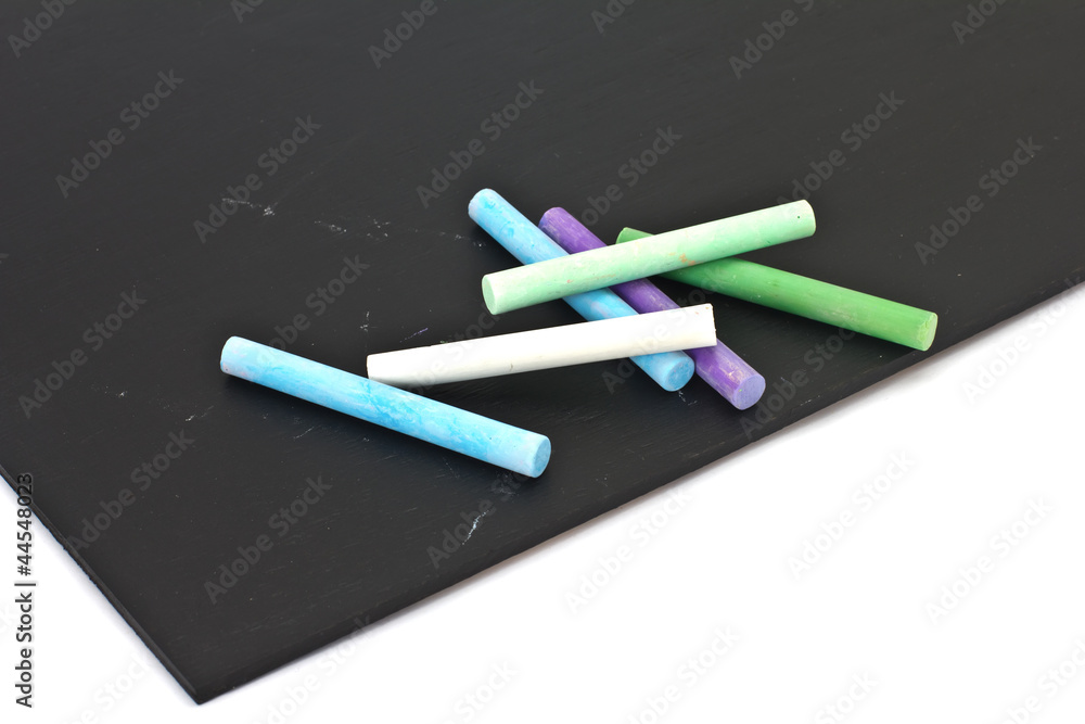 Set of colorful pieces of chalk on blackboard isolated on white Set of colorful pieces of chalk on blackboard isolated on white