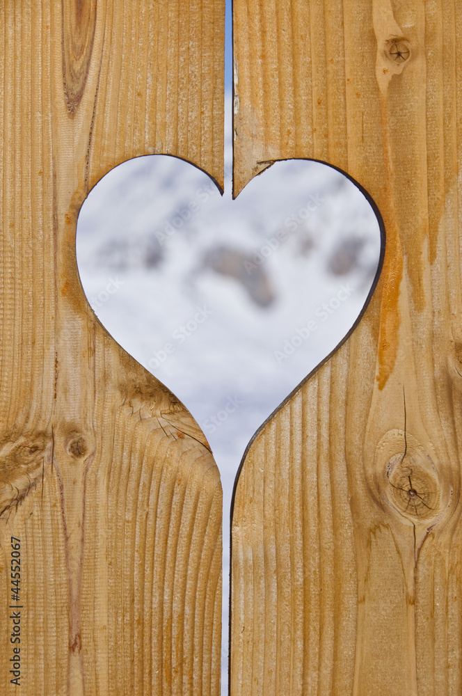 Naklejka premium Coeur en bois, fond neige