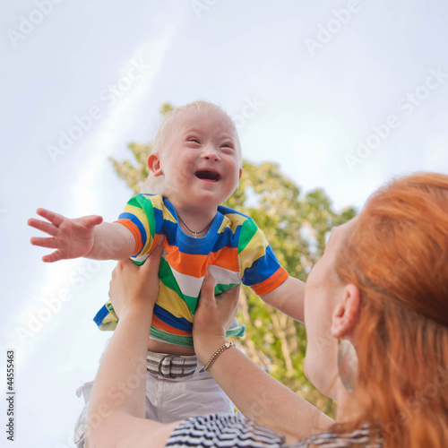 baby with Down syndrome is happy and flying up