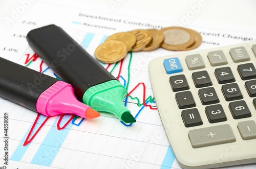 Calculator, coins and pen laying on chart photo