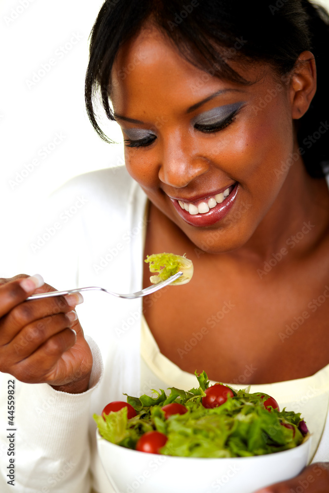 Young woman eating green salad on a bowl Young woman eating green salad on a bowl