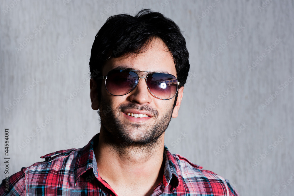 Obraz premium close up of a man wearing sunglasses against grey wall