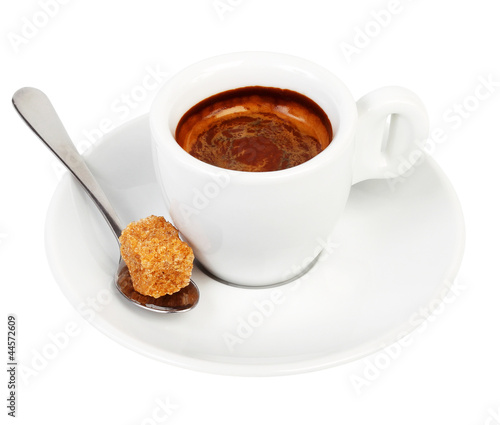 Coffee on a saucer and a spoon with a piece of cane sugar