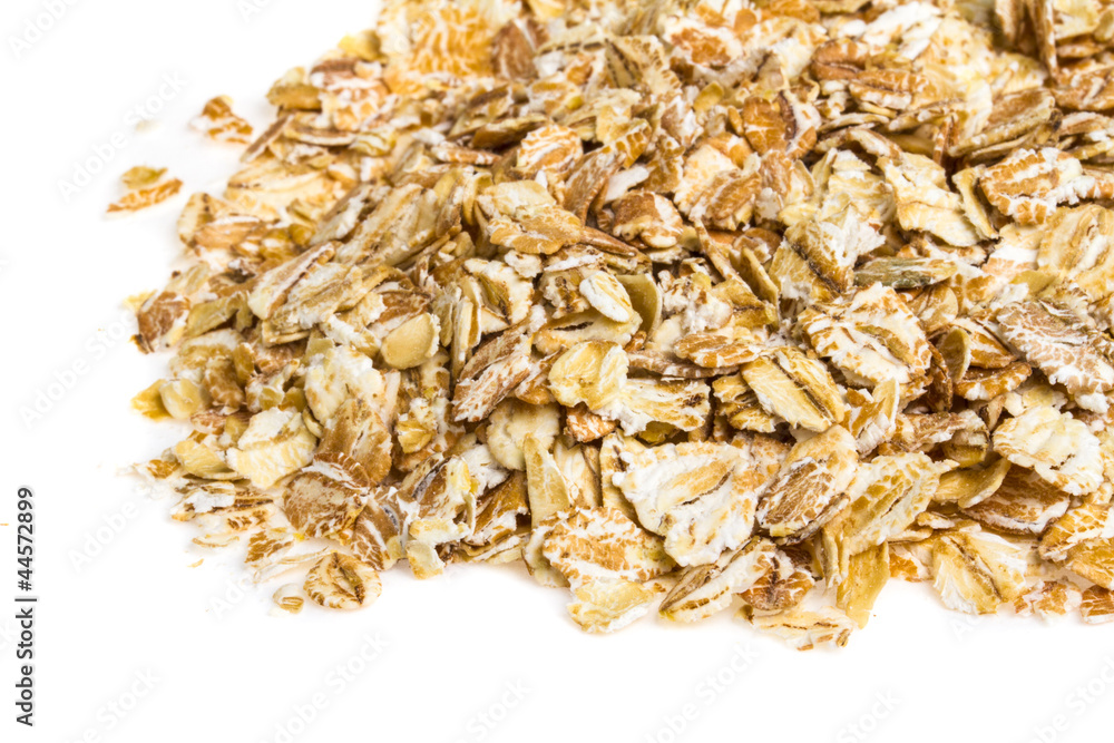 Heap of dry rolled oats isolated on white background