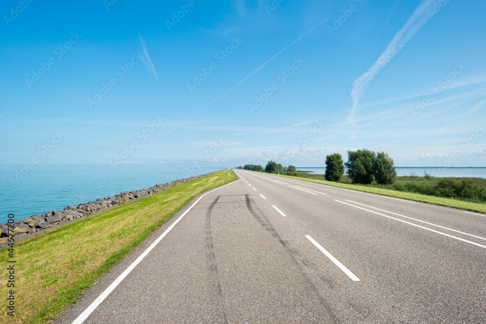 Fototapeta premium Road on a dike along a lake