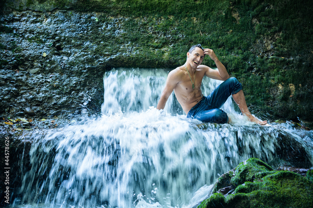 Happy young man having fun and relax under waterfall. Happy young man having fun and relax under waterfall.