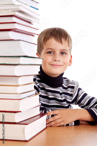 Schoolboy and a heap of books isolated on a white background