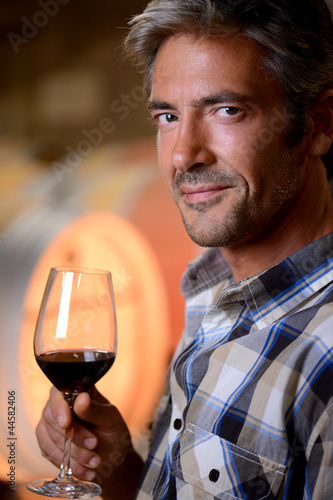 Closeup on winemaker smelling red wine in glass