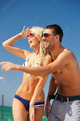 happy couple in sunglasses on the beach
