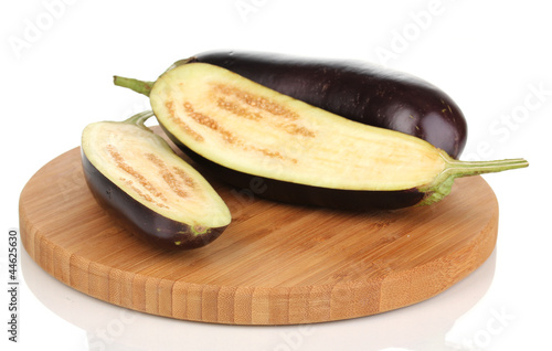 Fresh eggplant and halves on chopping board isolated on white