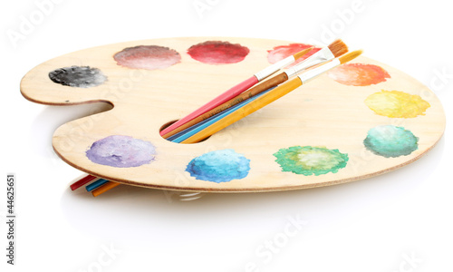 wooden art palette with paint and brushes isolated on white