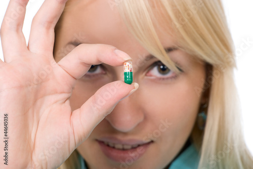 Young woman holds capsule - offering it to the patient