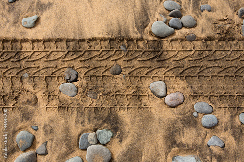 car tire footpring in a sand stones beach