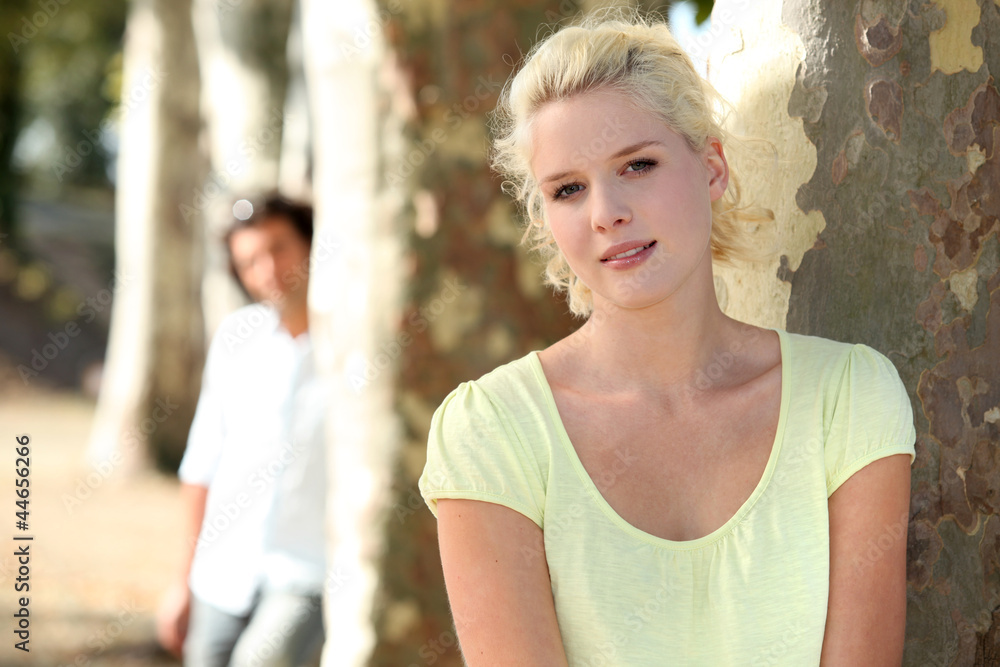 Fototapeta premium Couple standing in a park by trees
