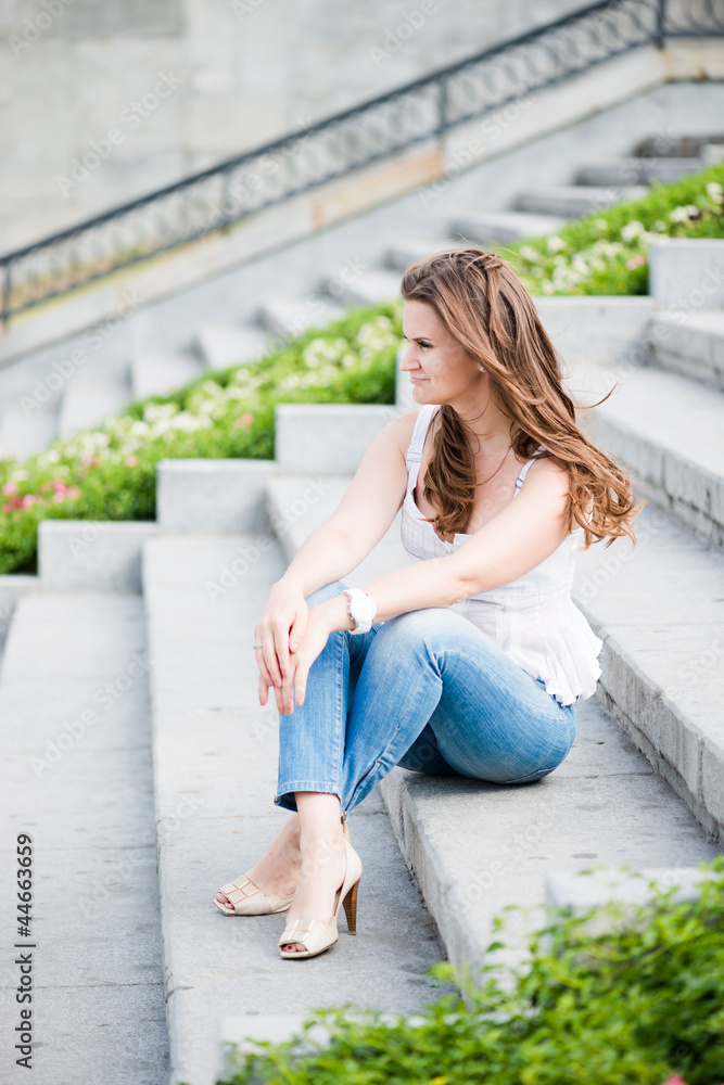 Portrait of a beautiful european woman sitting om steps Portrait of a beautiful european woman sitting om steps