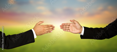 Two business male hands about to shake hands, over white backgro