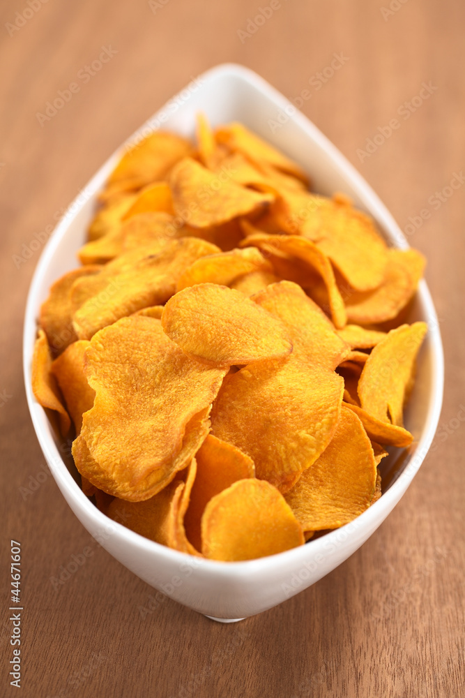 Crispy Peruvian sweet potato chips in white ceramic bowl Crispy Peruvian sweet potato chips in white ceramic bowl
