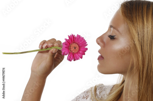 Fotografie Junge dunkelhaarige Frau riecht an rosa Blüte