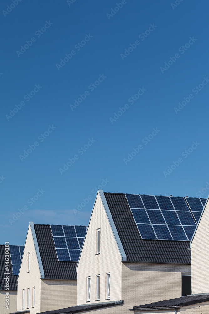 Fototapeta premium Row of new houses with solar panels on the roofs