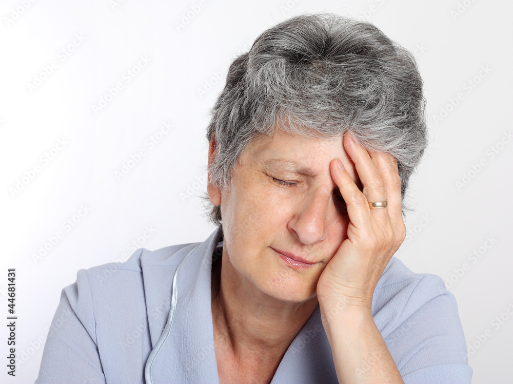 Portrait of a sad senior woman holding her head in pain Portrait of a sad senior woman holding her head in pain