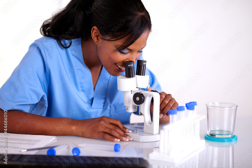 Scientific female in blue uniform using microscope Scientific female in blue uniform using microscope