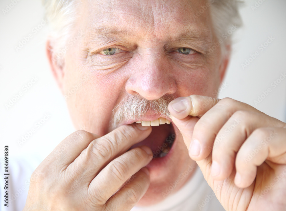 senior man flosses teeth senior man flosses teeth
