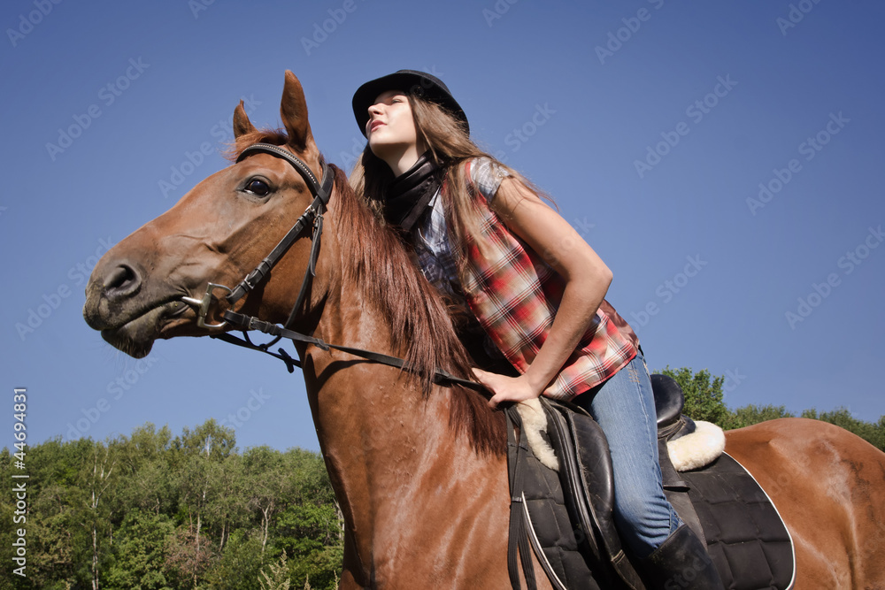 Fototapeta premium Cowgirl riding a bay horse