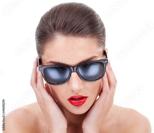 young woman straightening her sunglasses