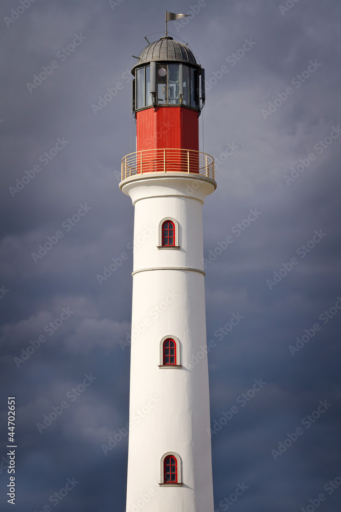 White lighthouse over dramatic cloudy sky