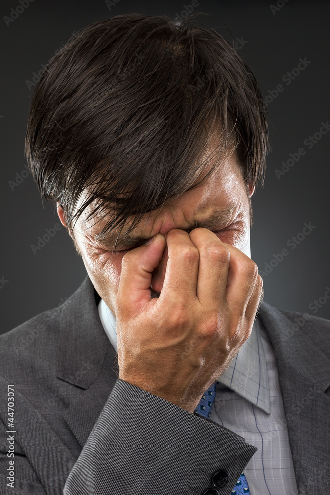 Closeup of young business man with headache Closeup of young business man with headache