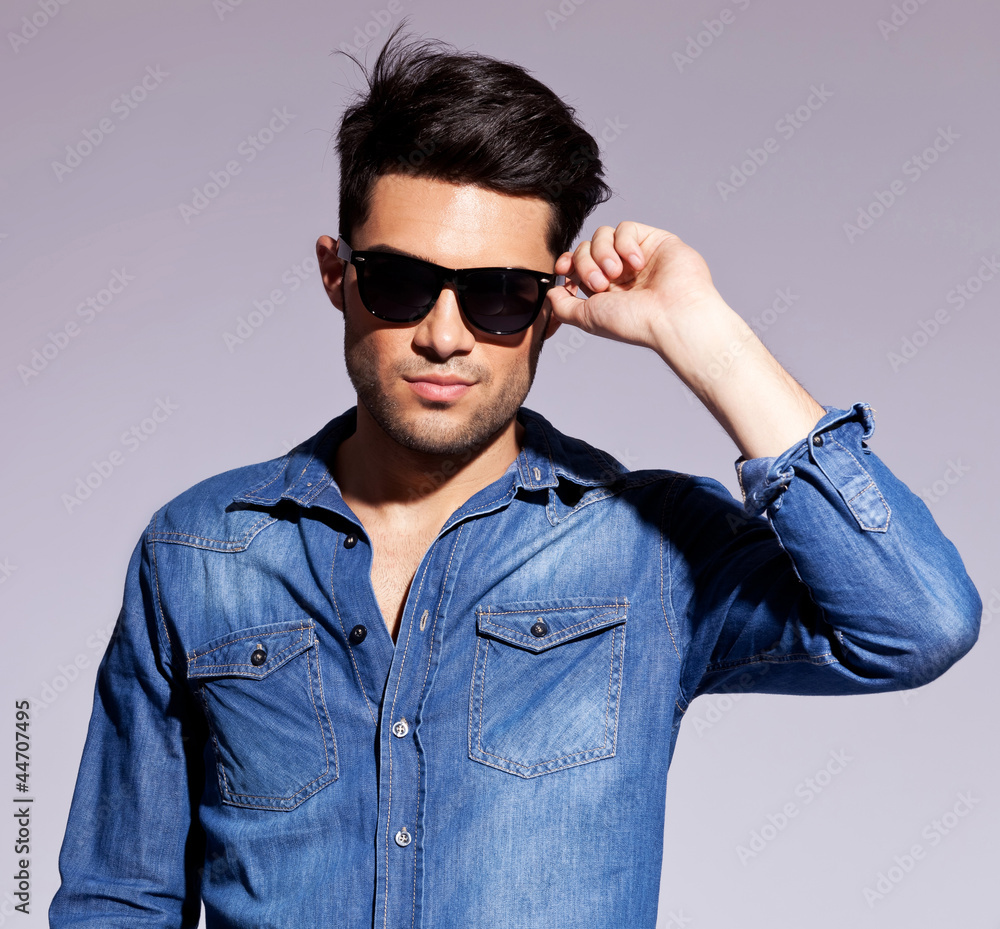 man holding his fashionable sunglasses man holding his fashionable sunglasses