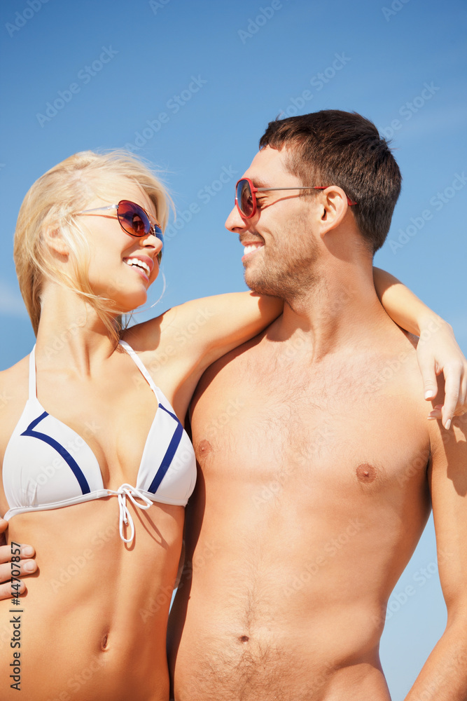 happy couple in sunglasses on the beach happy couple in sunglasses on the beach